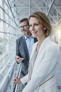 Smiling businesswoman and businessman at the airport