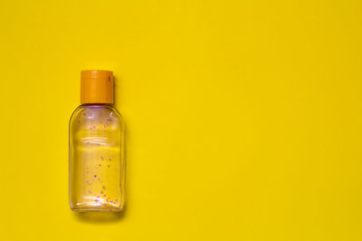 Close-up of bottle in glass against yellow background