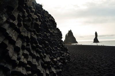 Rocks on beach against sky