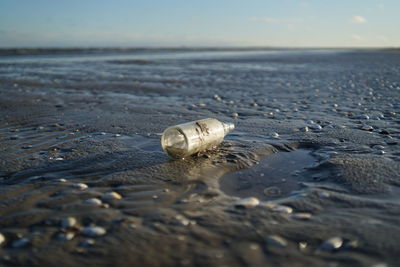 Empty glass bottle at beach