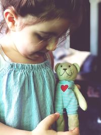 Midsection of woman holding girl at home