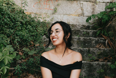 Smiling mature woman sitting against wall