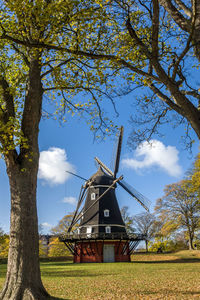 Traditional windmill on field against sky