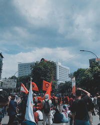 People on street in city against sky