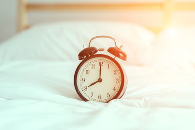 Close-up of clock on bed