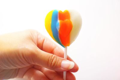 Close-up of hand holding multi colored balloons