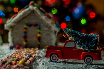 Close-up of toy car on christmas tree at night