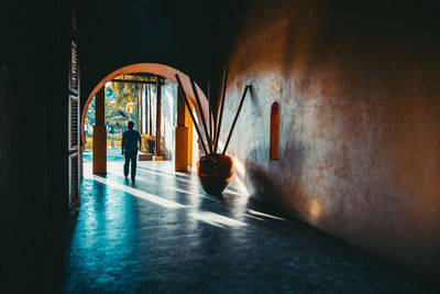 Rear view of man walking in corridor