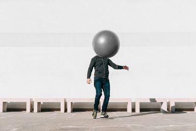 Full length of boy standing on balloons