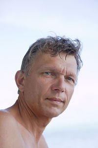 Close-up portrait of man against sky