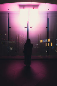 Rear view of man walking on street at night