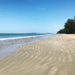 Scenic view of beach against clear blue sky