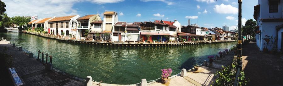 Panoramic view of canal amidst buildings in city