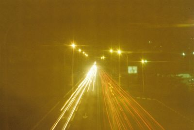 Road passing through illuminated tunnel