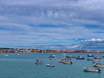 Sailboats moored in sea against sky