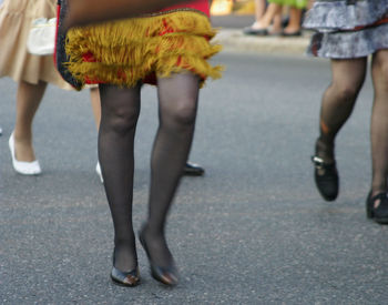 Low section of woman walking on road