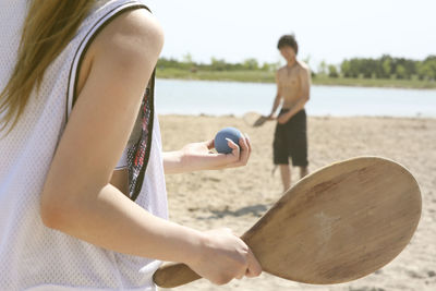 Midsection of woman playing with ball on beach