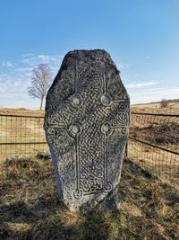 Close-up of sculpture on field against sky