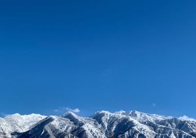 Scenic view of snowcapped mountains against clear blue sky