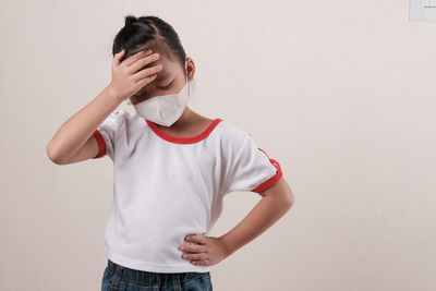 Full length of boy standing against wall