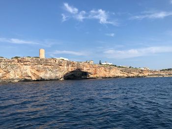 Sea by buildings against sky