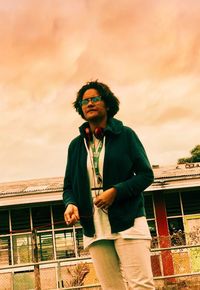 Young man looking away while standing against railing