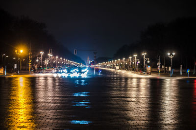 Illuminated bridge over river at night