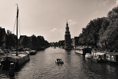 Sailboats moored in river against sky