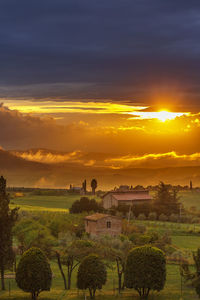 Sunset over a farm in a rolling tuscan landscape in italy