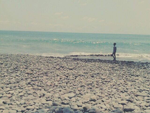 sea, horizon over water, beach, water, shore, lifestyles, leisure activity, sky, scenics, tranquil scene, full length, standing, beauty in nature, tranquility, rear view, nature, wave, sand