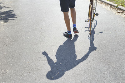 Low section of man with shadow on beach