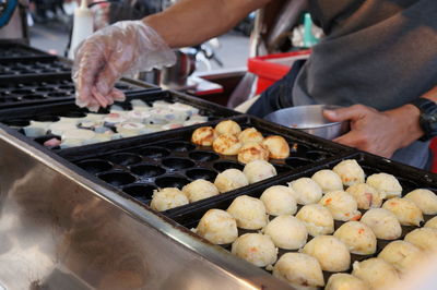 Midsection of person preparing food at market stall