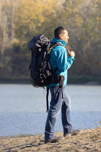 Portrait of traveler man at lake in autumn