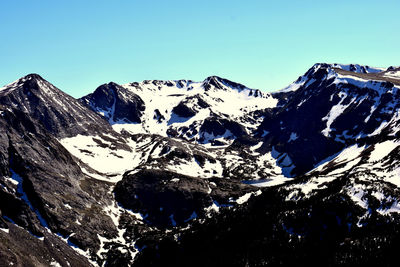 Scenic view of snowcapped mountains against clear blue sky