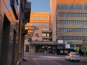 Cars on road by buildings in city