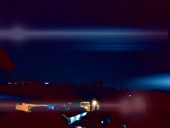 Aerial view of illuminated sea against sky at night