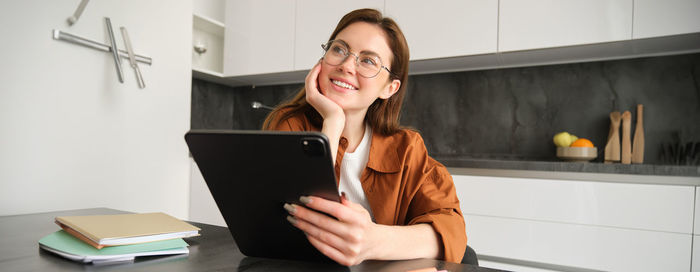 Young woman using laptop while sitting on table