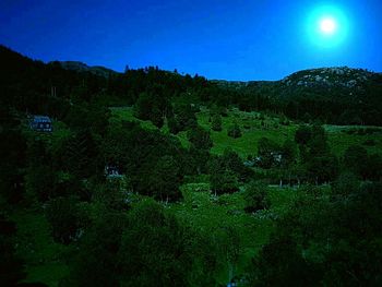 Scenic view of green landscape against clear blue sky