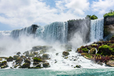 Scenic view of waterfall against sky