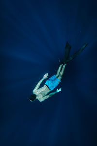 High angle view of shirtless man swimming undersea