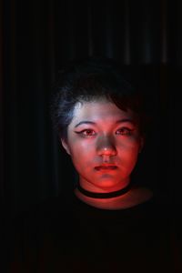 Low lit portrait of a young girl with colored light as accent