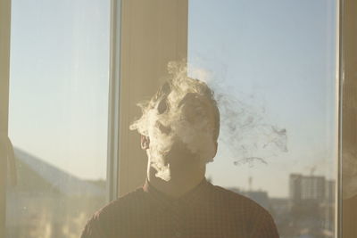 Portrait of young man smoking window