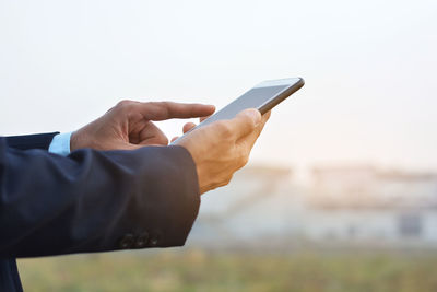 Midsection of man using mobile phone