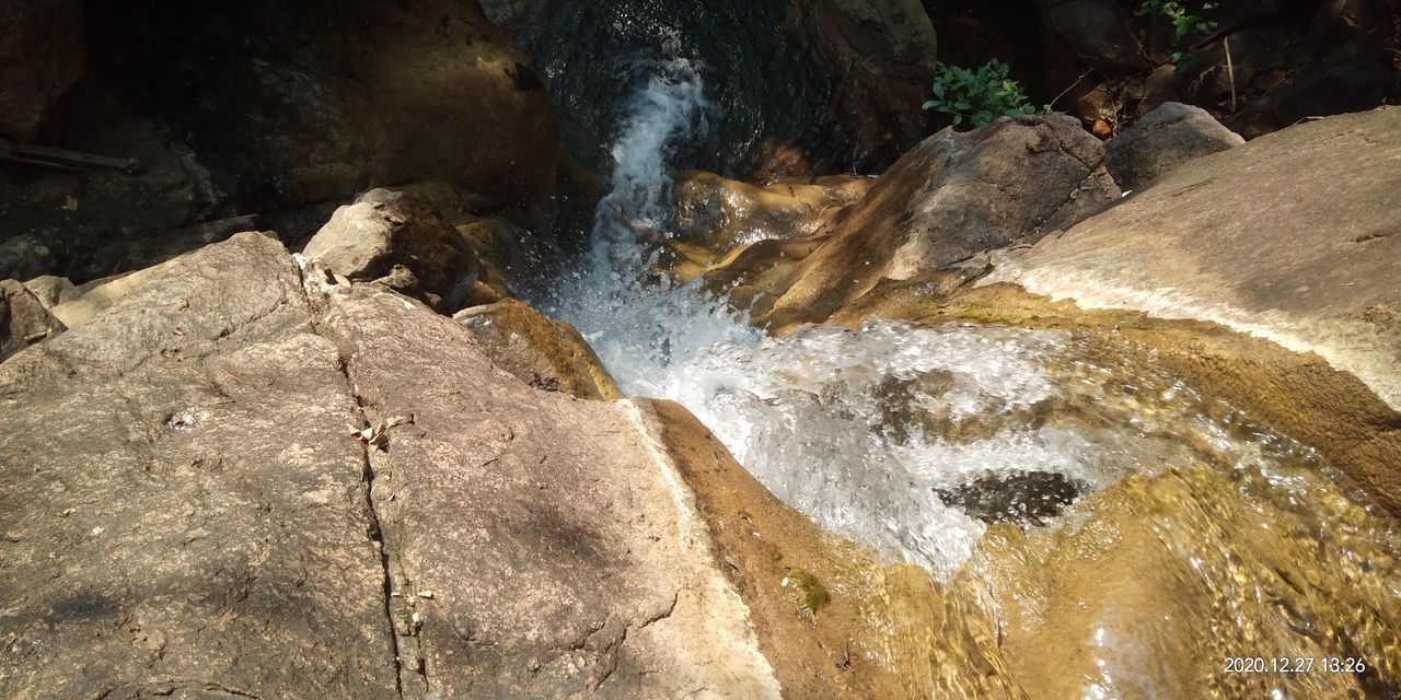 HIGH ANGLE VIEW OF WATER SPLASHING ROCKS