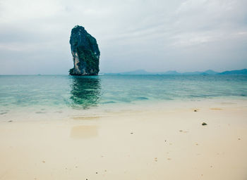 Scenic view of rock formation by sea against sky