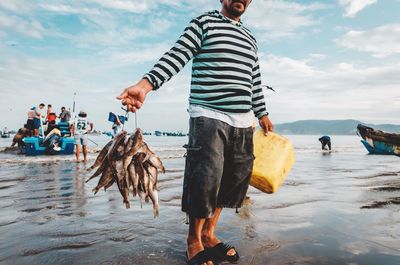 Man standing on beach against sky