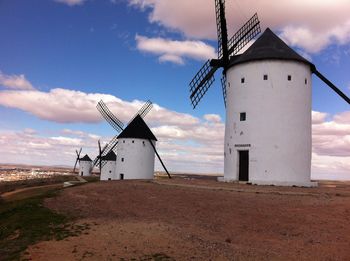 Traditional windmill on field against sky