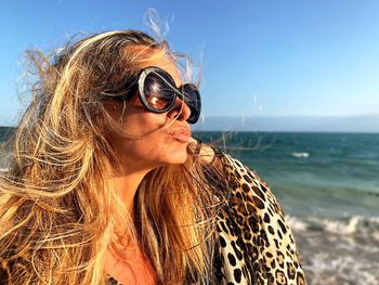 Woman wearing sunglasses against sea and sky
