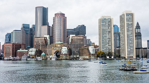 Boats moored on charles river against boston harbor