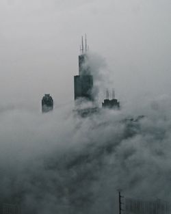 Tower and buildings in city against sky